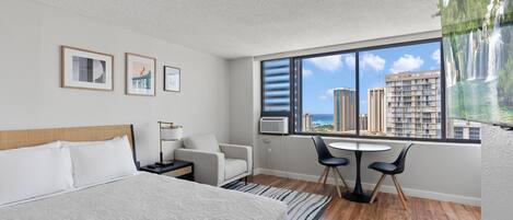 Room picture with view of Ala Wai Canal, queen bed, and dining t