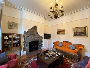 Lounge with Manx stone fireplace, original stripped pine flooring and lots of vintage decor for 8 pe