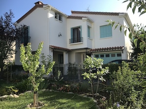 The newly painted house has a pool and gardens
