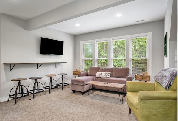 Upper level living room with ample seating and flat-screen Roku TV.