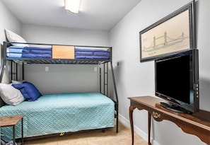 Third bedroom with twin over full bunk bed with twin trundle bed and flat-screen Roku TV on first floor.