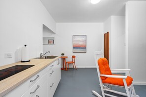 Functional living room with an orange table and chairs, perfect for meals or working on your laptop.