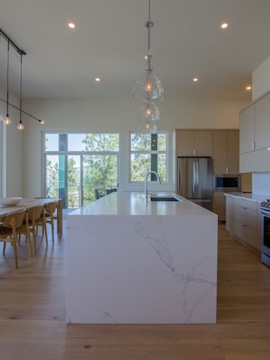 Large well equipped kitchen with quartz waterfall island to prep gourmet meals