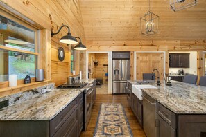Chef's kitchen with farmhouse-style sink, dishwasher, and standard drip coffeemaker.
