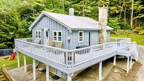 The home features a large deck that wraps around the front and side of the home