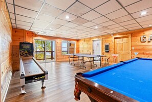 The game room of this cabin has it all—pool, ping pong, skee ball, and arcade games, offering endless fun and friendly competition for all ages.