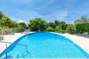 Grande piscine avec escalier et transats