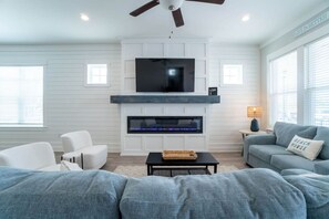 Living Room: Bright space with a sleek fireplace, perfect for lively gatherings and beach vibes!