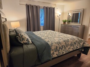 Master bedroom with a king mattress and a matching dresser. 