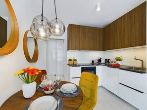 Dining area with kitchenette equipped with high quality appliances (oven with microwave, coffee maker, toaster, dishwasher) that will allow you to prepare your favourite meals.