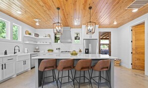 Prepare meals in this modern kitchen featuring a large island and stylish barstools.