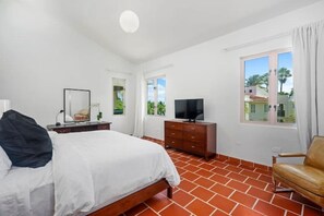 Primary bedroom with king-size bed, ensuite bathroom and soaring 20' ceilings