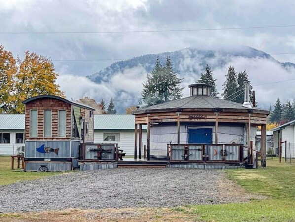 Exterior of the yurt and the tiny home, surrounded by mountains.