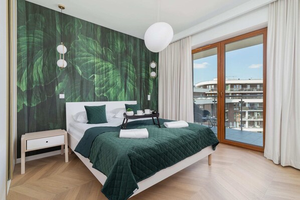 Bedroom with a comfortable double bed, wardrobe and access to balcony.