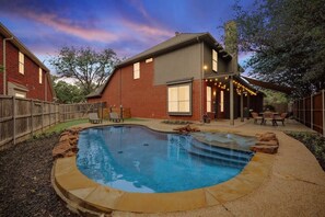 Welcome to your very own tropical pool paradise from the convenience of your backyard! With a pool, string lights, patio, lounge chairs, and landscaping, what more could one want?