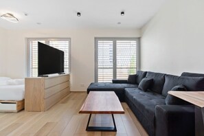 Spacious living area with a smart TV and stylish seating, ideal for relaxation and entertainment.
