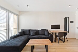 Cozy up in this inviting living space with ample natural light and a large, comfortable couch.