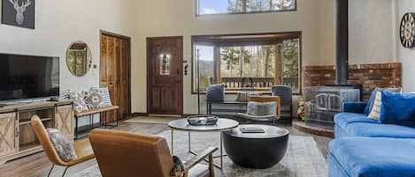 Surrounded by trees and beautiful mountain views, the home features soaring windows and an open and social main living space perfect for a mountain getaway.