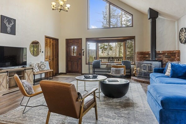 Surrounded by trees and beautiful mountain views, the home features soaring windows and an open and social main living space perfect for a mountain getaway.