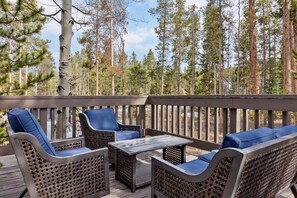 Enjoy the fresh mountain air and views of the surrounding trees out on the spacious deck, the perfect space for entertaining with a bbq, picnic table, and an outdoor patio set with seating for 4.