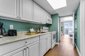 Whip up delicious meals in this fully equipped kitchen, featuring modern appliances and a sleek design. With the ocean breeze just steps away, it’s the perfect blend of convenience and coastal charm for your getaway.