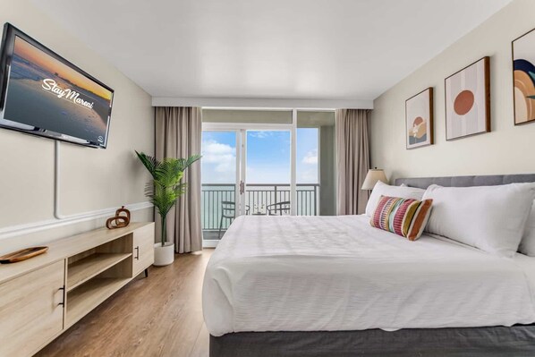 Wake up to panoramic ocean views in this serene bedroom featuring a plush king-size bed, stylish décor, and balcony access. Perfect for unwinding after a day of beach adventures!