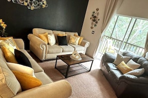 Living room with 2 sofas and 1 love seat -sliding door to balcony w/pool view