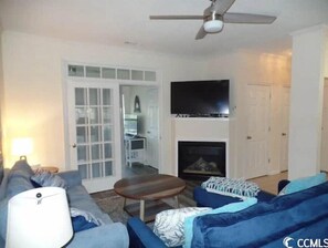 Living room with mounted TV above fire place