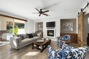 Open living room with gas fireplace.   Sleeper sofa