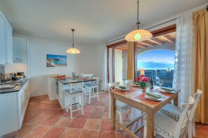 Living room with equipped kitchen, breakfast table and dining table