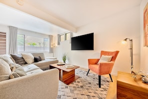 Living room with sectional couch and large flat screen TV