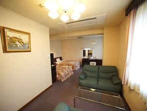 ・ [Example of deluxe twin room] A sofa set with a calm color tone is installed.