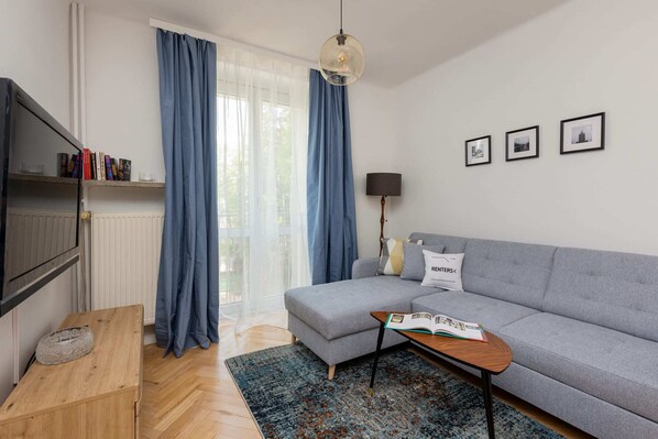 Stylish living room with a corner sofa bed, coffee table and TV.