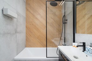 The bathroom features a modern bathtub and sleek fixtures. 