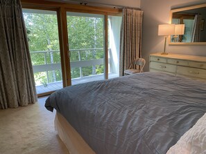 Primary bedroom has large deck and sliding glass doors with black-out curtains.