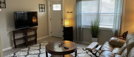 Comfortable living room next to the eat in kitchen with dual reclining sofa.