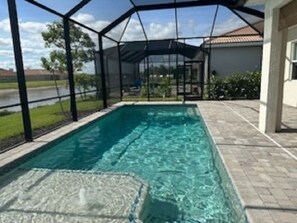 View across caged pool deck. 