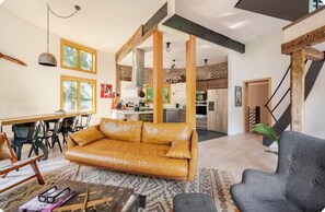 Living room including dining table and kitchen in the background