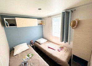 Bright and welcoming twin bedroom, offering a peaceful space for relaxation.