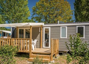 A charming mobile home with a sunny deck, perfect for relaxing outdoors in comfort.
