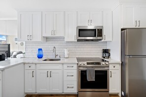 Modern kitchen with basic appliances, sleek counters, and stylish cabinetry