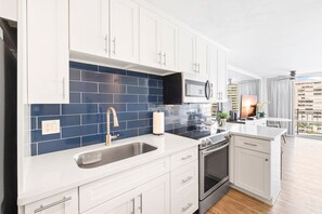 Modern kitchen with basic appliances, sleek counters, and stylish cabinetry