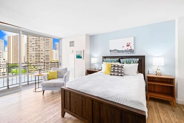 Bright studio with a queen bed, and private balcony offering city views.