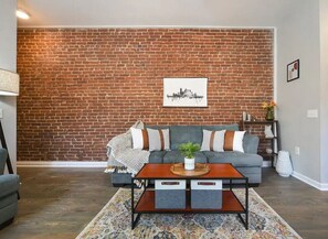 Relax in this comfortable living room with exposed brick.