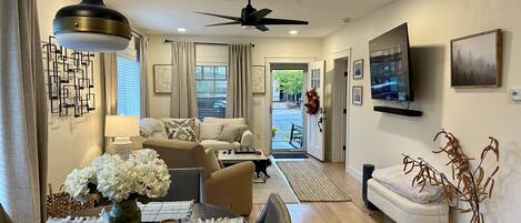 Open concept living room. Large picture windows, crate & barrel couch, 64 in TV