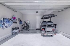 A fully equipped garage featuring a golf cart, bicycles, and beach gear, ensuring easy exploration and outdoor fun.