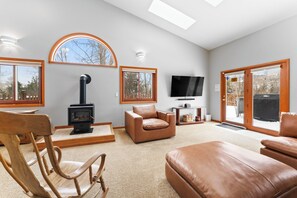 Spacious living area with gas fireplace, ample seating, and deck access.
