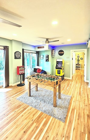 The game room has a dart board, gumball machine, foosball, and arcade game!