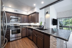 Updated modern kitchen with stainless steel appliances and granite countertops.