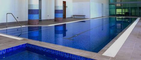 Indoor heated pool next to apartment